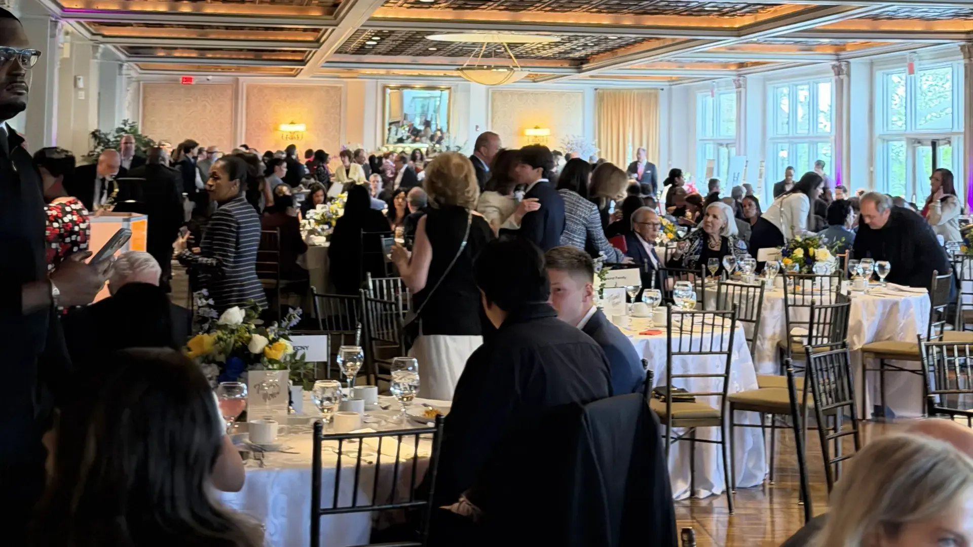 Guests attending the Monroe Foundation fundraising gala in a formal banquet hall.