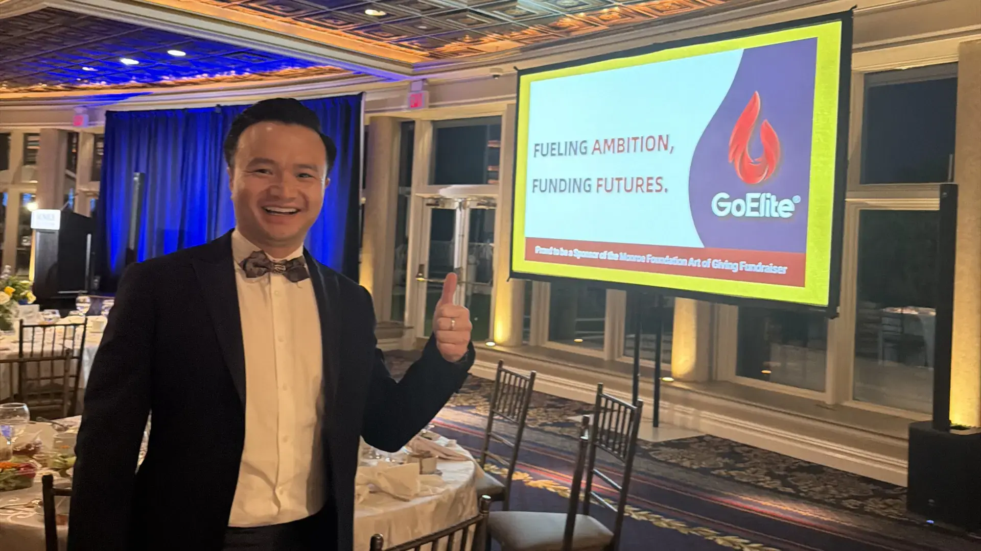 GoElite sponsor display at the Monroe Foundation fundraising gala with company representative.