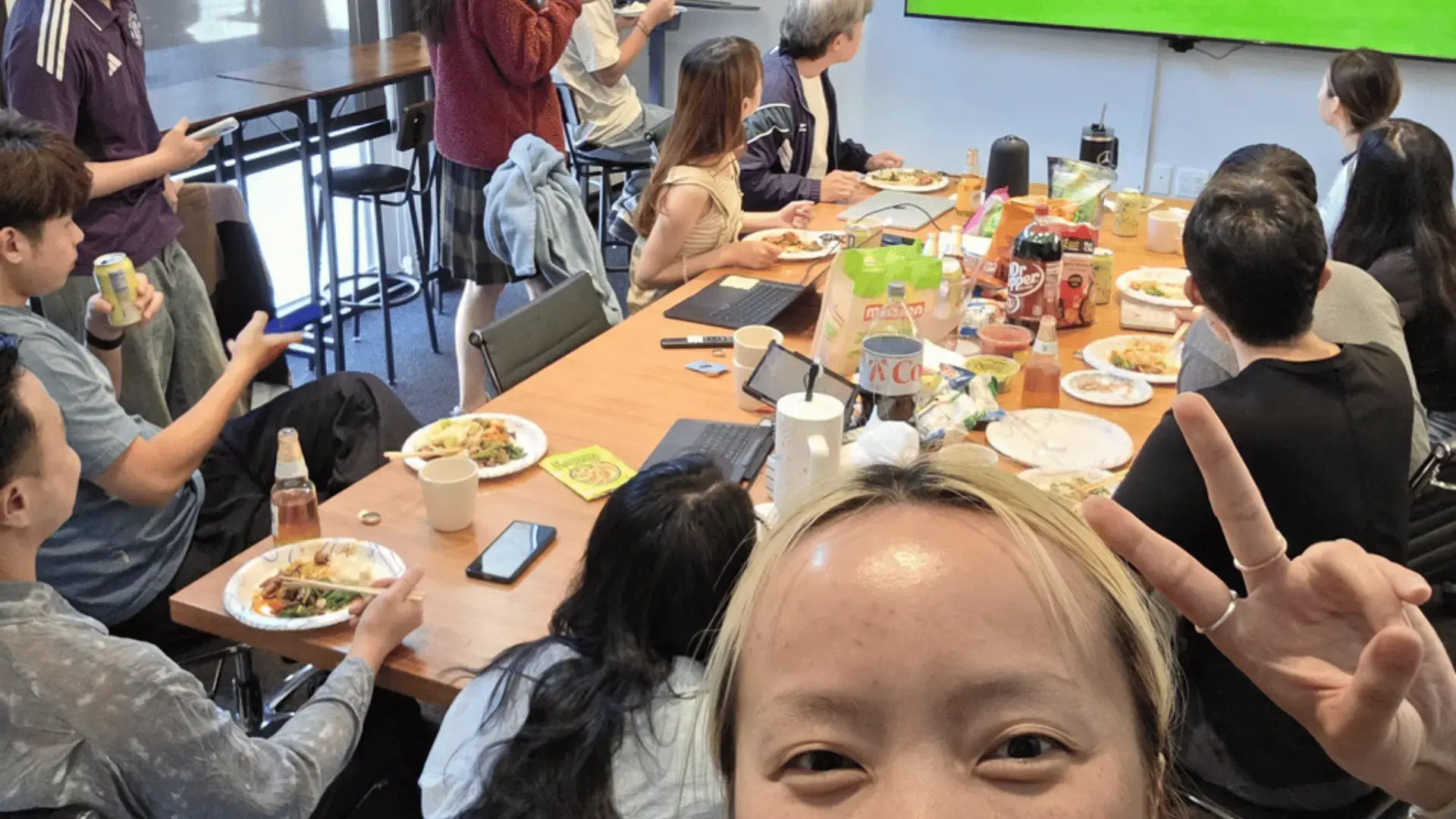 GoElite team members sharing a meal and watching a World Cup match together during an office gathering.